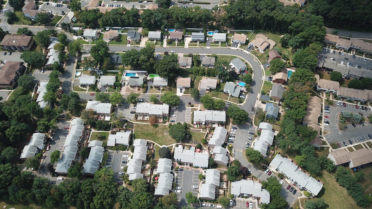 Services Drone view of a suburban residential area with houses and tree-lined streets in Woodbridge Township, NJ.